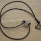 Pendant with dark brown, round leather cord<br>Secured with bead